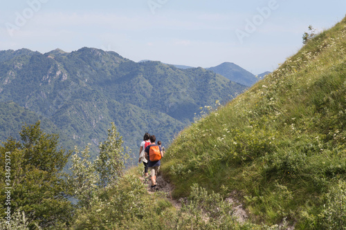 Tourists walking on a trail in mountains.