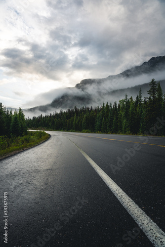 road in the mountains with morning mist and fog after sunrise 