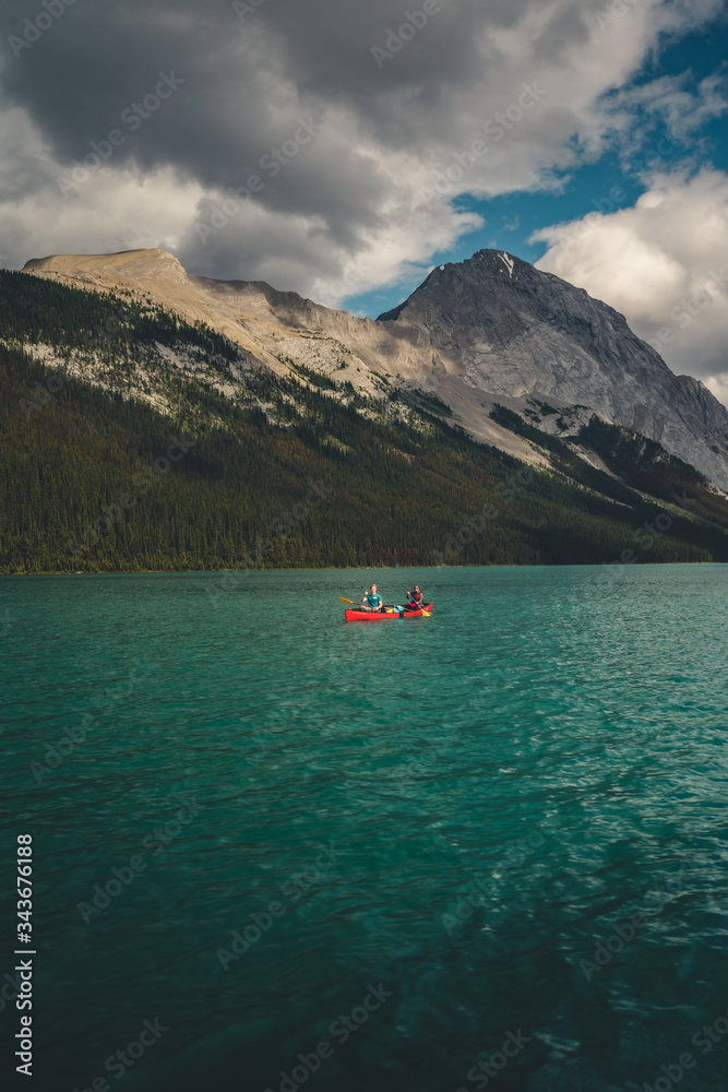 canoe on the lake with mountain background and cloudy weather 