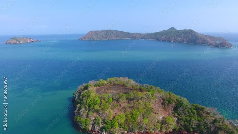 Hover Aerial View of Islands Adjacent to Bona Island Tip with Sparse Foliage, Rocky Shoreline and Bluw Sky Hover Aerial View of Islands Adjacent to Bona Island Tip with Sparse Foliage, Rocky Shoreline and Bluw Sky