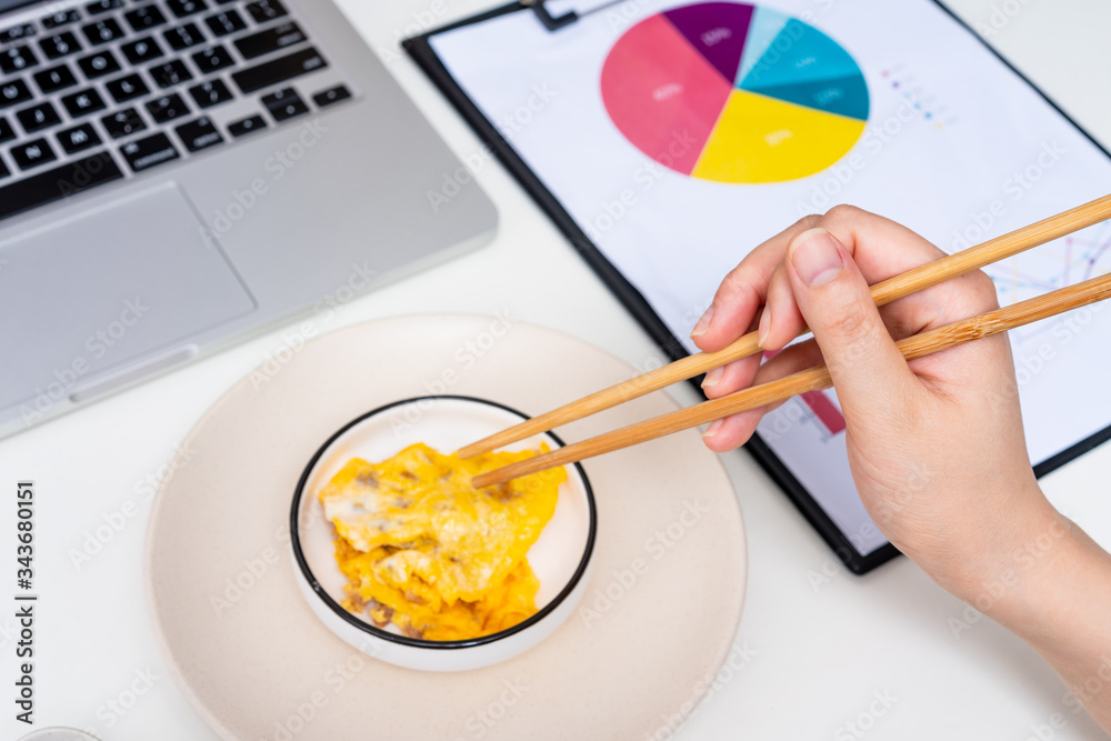 Asian female eating breakfast at the desk Asian female eating breakfast at the desk