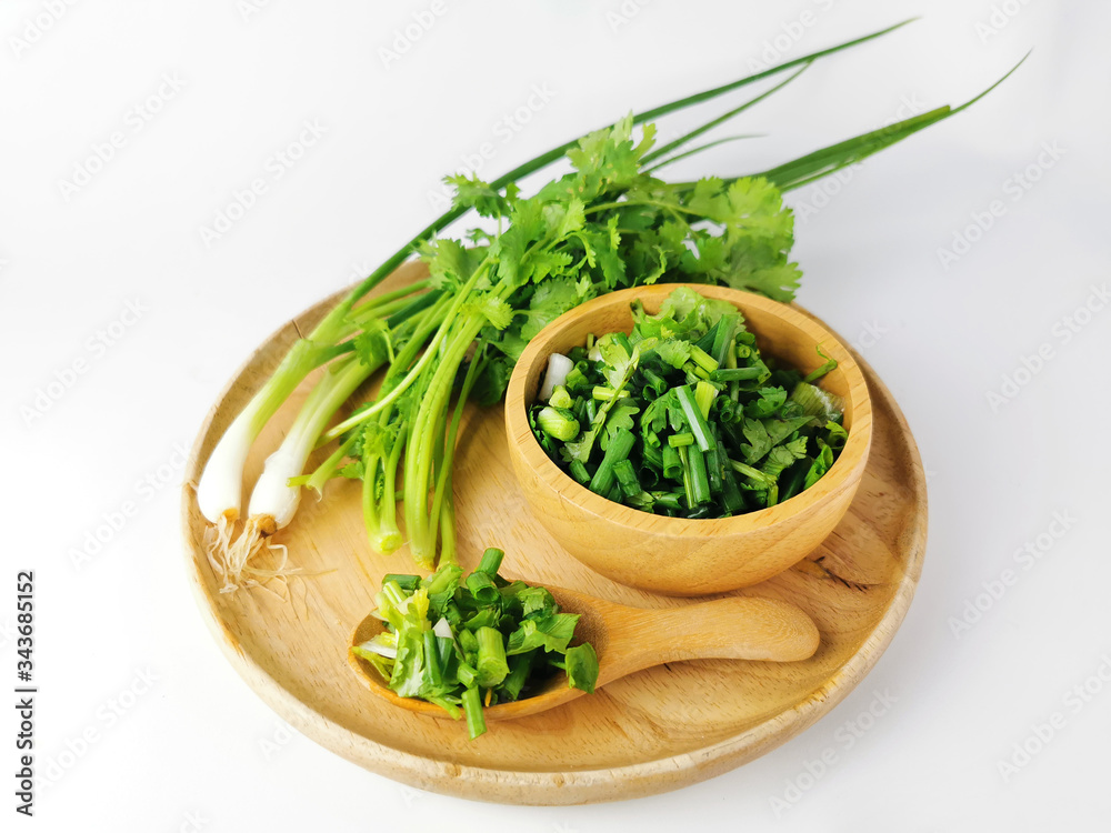 Fresh Spring onion, coriander in a wooden tray , Cut into small pieces in wooden spoon, wooden cup Fresh Spring onion, coriander in a wooden tray , Cut into small pieces in wooden spoon, wooden cup