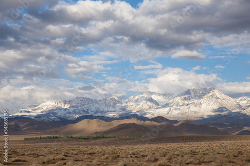 desert landscape with snowy mountain peaks and clouds