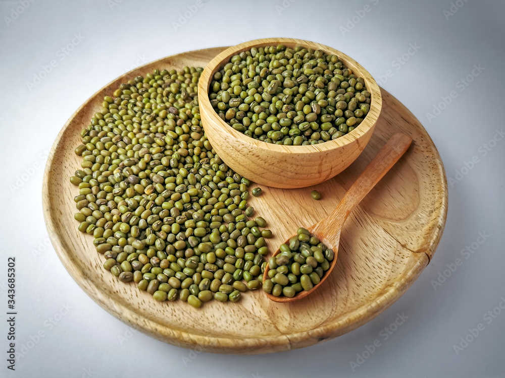 Green beans seed in a wooden tray, wooden spoon, wooden cup on Soft lights background Green beans seed in a wooden tray, wooden spoon, wooden cup on Soft lights background