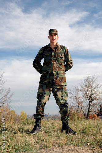 Young  USA military soldier stands  at ease on a hill top