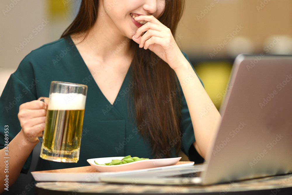 PCを見ながらお酒を飲む女性 PCを見ながらお酒を飲む女性