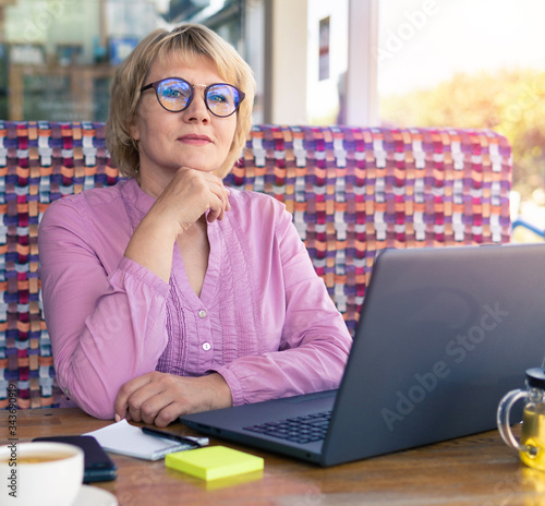 A woman is working with a laptop at a table in the room