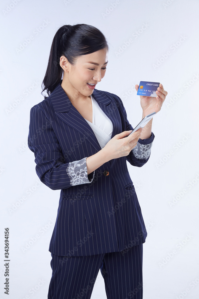 Asian woman using credit card and mobile phone. isolated over white background Asian woman using credit card and mobile phone. isolated over white background