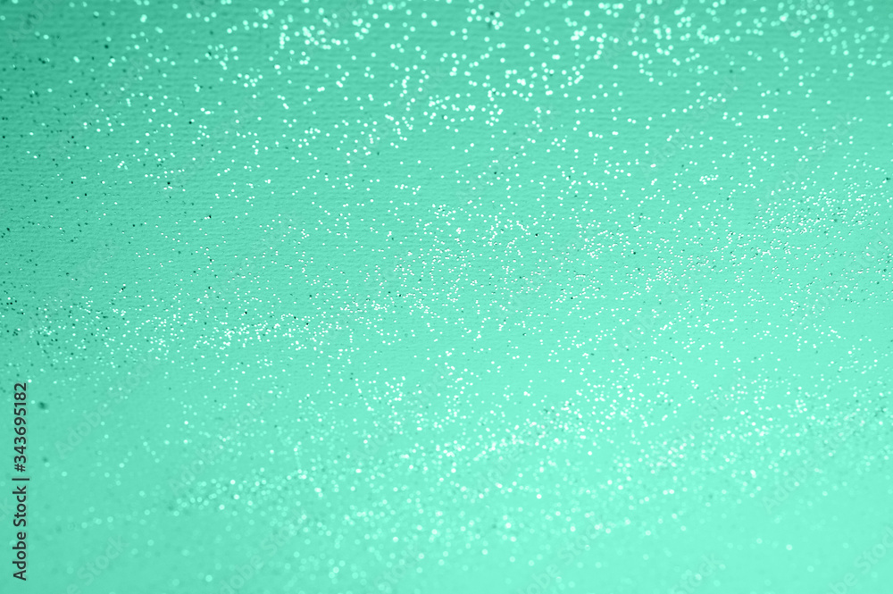 mint green backgdrop with silver sequins and bokeh from sequins. festive texture in biscay green color