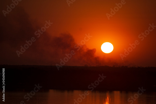 sunset over the countryside with smoke