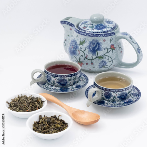 cup with tea and teapot on white background, over light 
