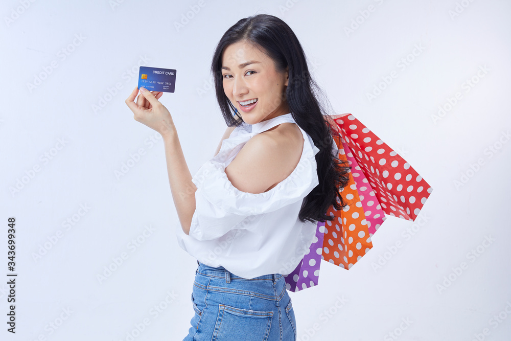 Shopping concept. Overjoyed woman holding credit card and paper bags Shopping concept. Overjoyed woman holding credit card and paper bags