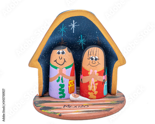 Mexican handcrafted Christmas decoration of holy family on white background, colorful Maya clay house with the nativity scene photo