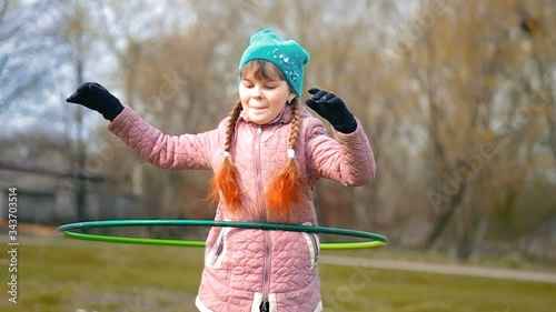 Girl in jacket spins hoop