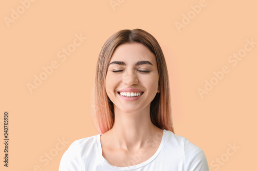 Young woman with healthy teeth on color background © Pixel-Shot