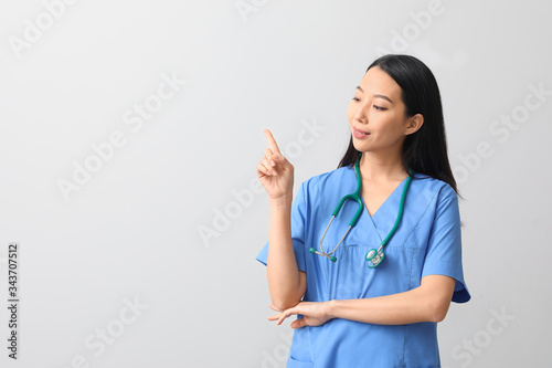 Female Asian doctor pointin...