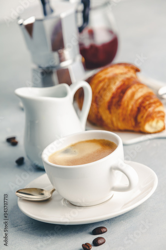 Coffee espresso in white cup with milk  jam and croissants.