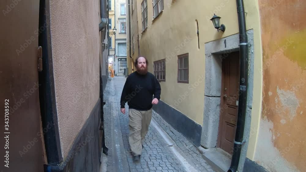 Swedish Man Casually Strolls Down Gamla Stan Alley. Stockholm, Sweden Swedish Man Casually Strolls Down Gamla Stan Alley. Stockholm, Sweden