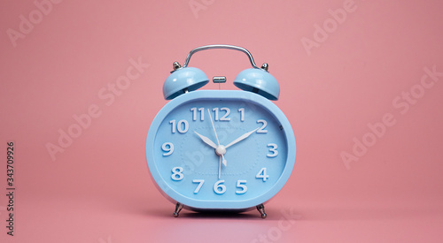 Blue Alarm clock isolated show time 10.10 am or pm, on pink background, Copy space for your text, Time concept. .