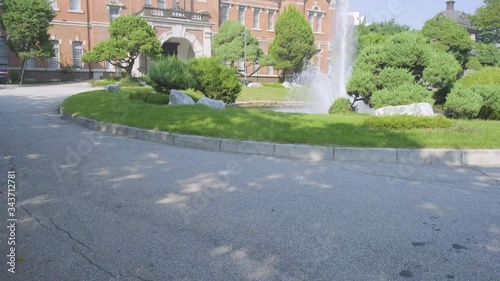 Camera tilt up from ground to reveal historic Daehan Hospital brick building front facade in Seoul National University Hospital complex in South Korea photo