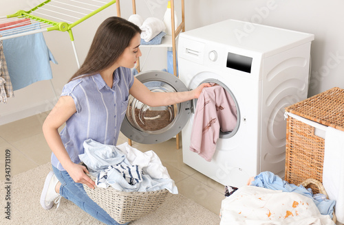 Young woman doing laundry a...