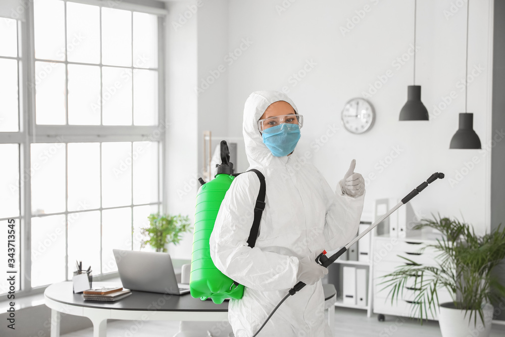 Worker in biohazard suit disinfecting office - obrazy, fototapety, plakaty 