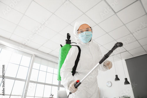 Worker in biohazard suit di...