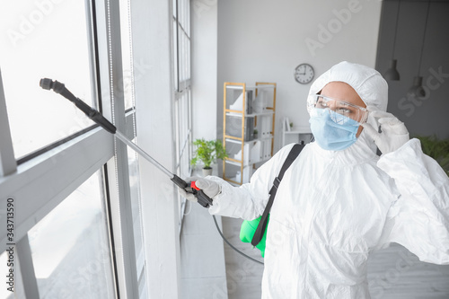 Worker in biohazard suit di...