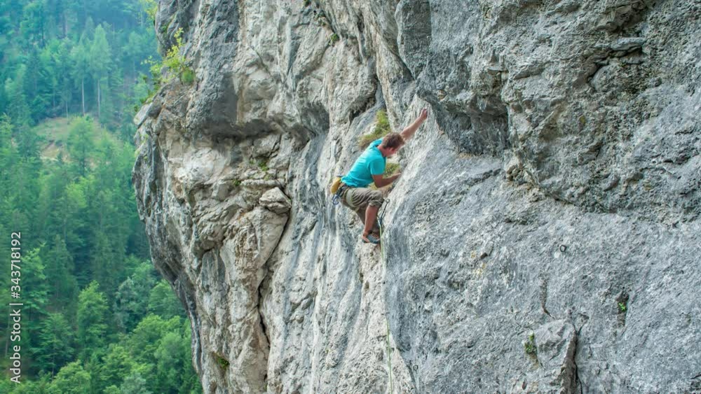 Man rock climbing up a mountain rocky vertical wall, area Burjakove peci, Alps.