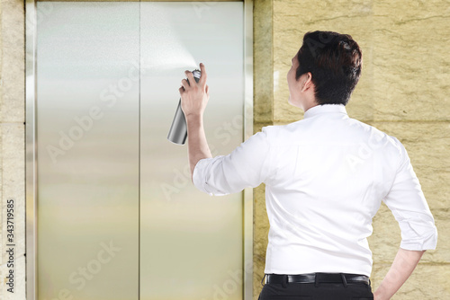Asian businessman spraying disinfectant in the office building