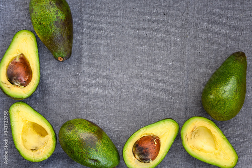 Opened avocado showing seed on textured grey linel background. Top view, Copy space photo