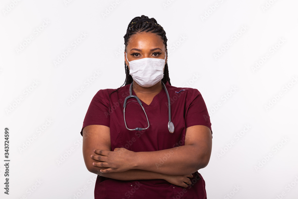 African american doctor in a medical mask over white background. Medicine, healthcare and people concept.