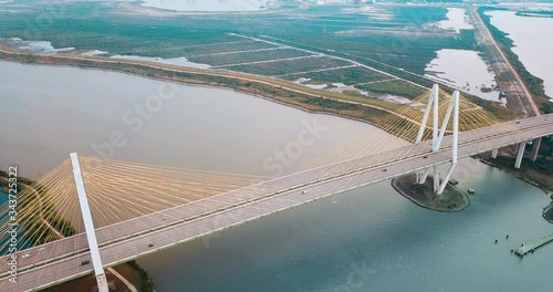 Aerial View Over a Cable-stayed Bridge Crossing over the Houston Ship Channel. Drone footage of the Fred Hartman Bridge connecting Houston and Baytown. Orange teal color grading. Wide angle. photo