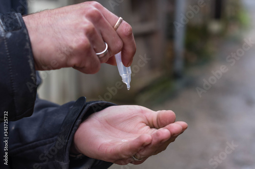 close up hands of a male using antiseptic on the black studio background © breng08