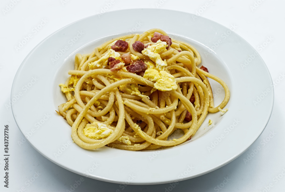Homemade traditional Italian Spaghetti alla carbonara with egg yolk isolated on white Homemade traditional Italian Spaghetti alla carbonara with egg yolk isolated on white