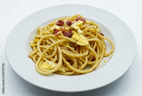 Homemade traditional Italian Spaghetti alla carbonara with egg yolk isolated on white