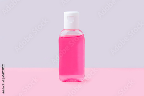 A small bottle with antiseptic sanitizer gel for washing hands on pink background. Alcohol gel as coronavirus prevention. Viral disease prevention concept. Copy space for text, flat lay