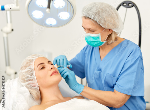 Fotografi Portrait of woman during beauty facial injections in medical esthetic office