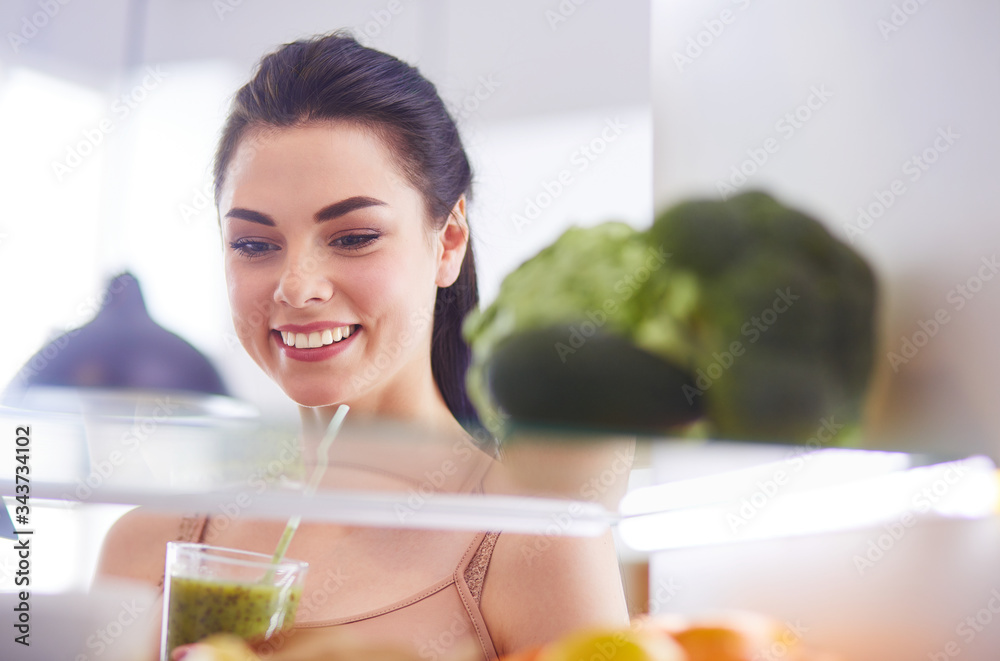 Young woman with glass of tasty healthy smoothie at table in kitchen Young woman with glass of tasty healthy smoothie at table in kitchen