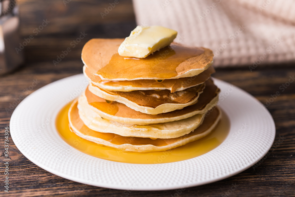 Golden pancakes with butter and warm maple syrup. Golden pancakes with butter and warm maple syrup.