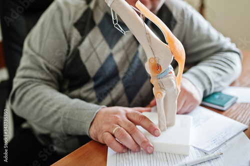 Artificial human knee joint model in medical office on table. photo