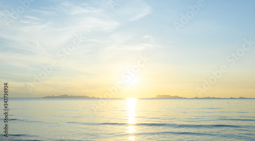 Beautiful beach sunrise with blue sea and golden light sky cloud background