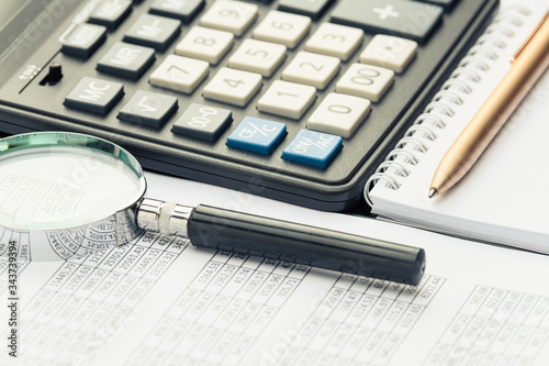 Business financial documents, office calculator and pen on the table. Numbers and graphs