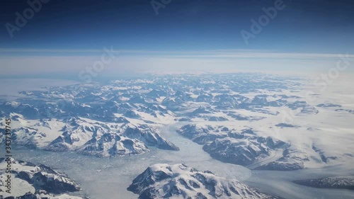Greenland icebergs and white top mountains from airplane