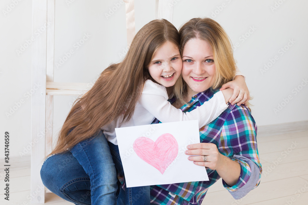 Mother's Day, holidays and family holidays - Mother holds greeting card from her lovely daughter. Mother's Day, holidays and family holidays - Mother holds greeting card from her lovely daughter.