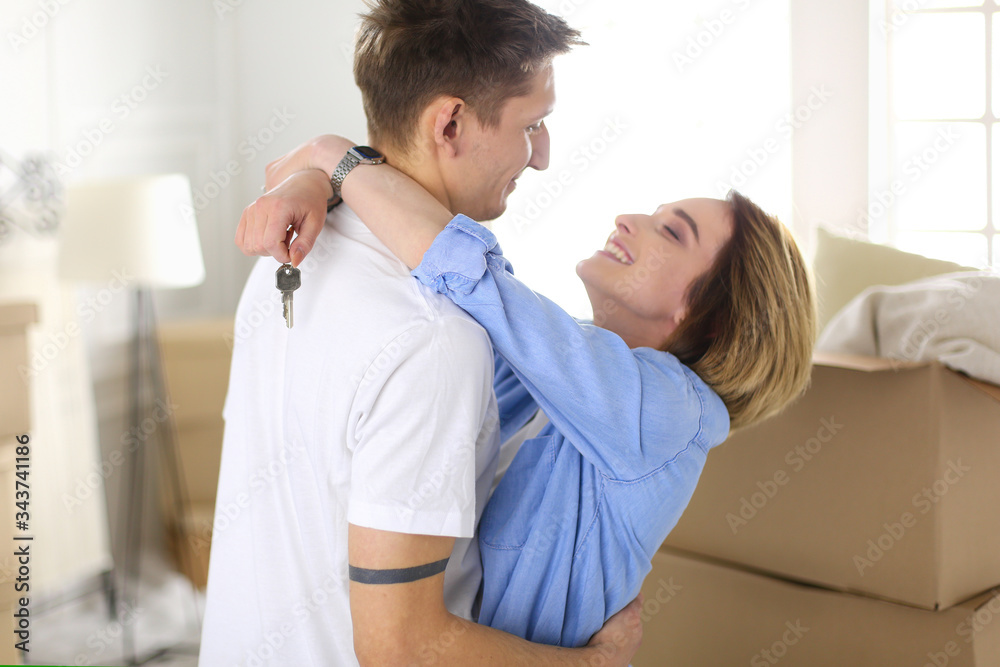Happy smiling young couple showing a keys of their new house Happy smiling young couple showing a keys of their new house