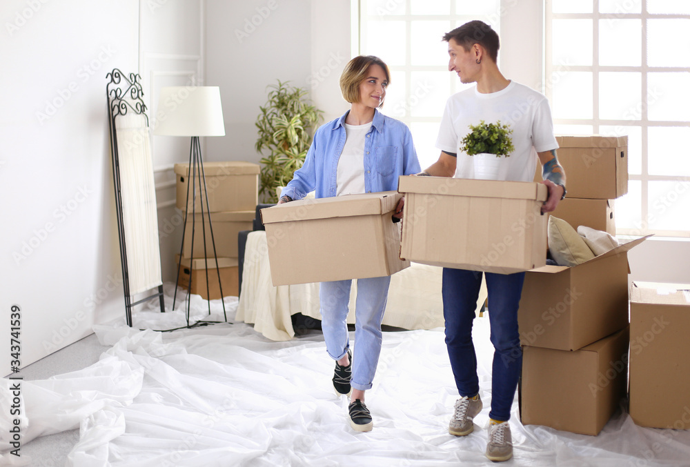 Couple holding boxes for moving the hands and looking inside box Couple holding boxes for moving the hands and looking inside box