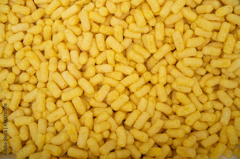 Yellow corn sticks close-up. Background of corn sticks. Harmful sweet food. Diabetes. Yellow corn sticks close-up. Background of corn sticks. Harmful sweet food. Diabetes.