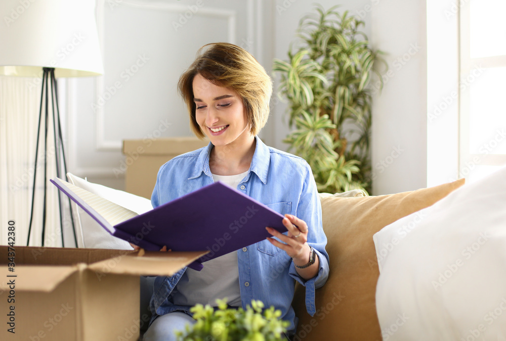 Young woman moving out and packing cardboard box Young woman moving out and packing cardboard box