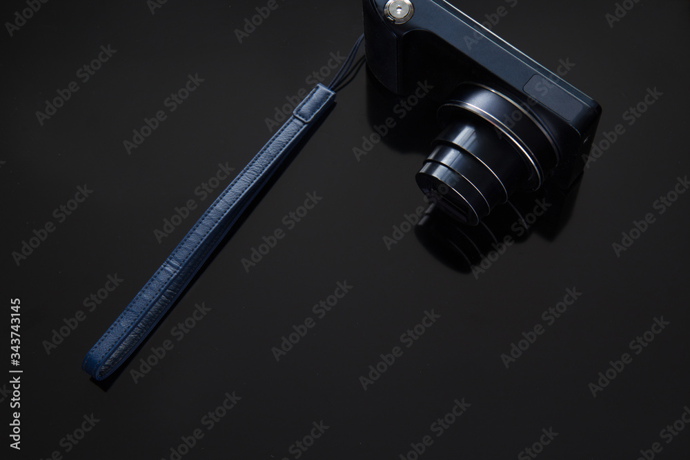 Obraz premium Dark blue camera on a black background, there is space for text. The concept of black minimalism.